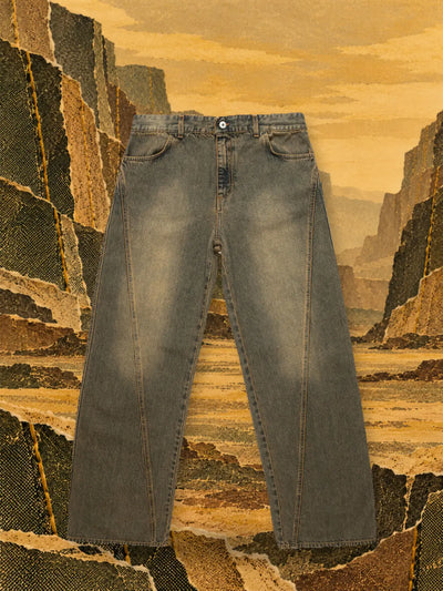 The brown Aged jeans in a canyon of ochre and olive paper, under a golden sky.