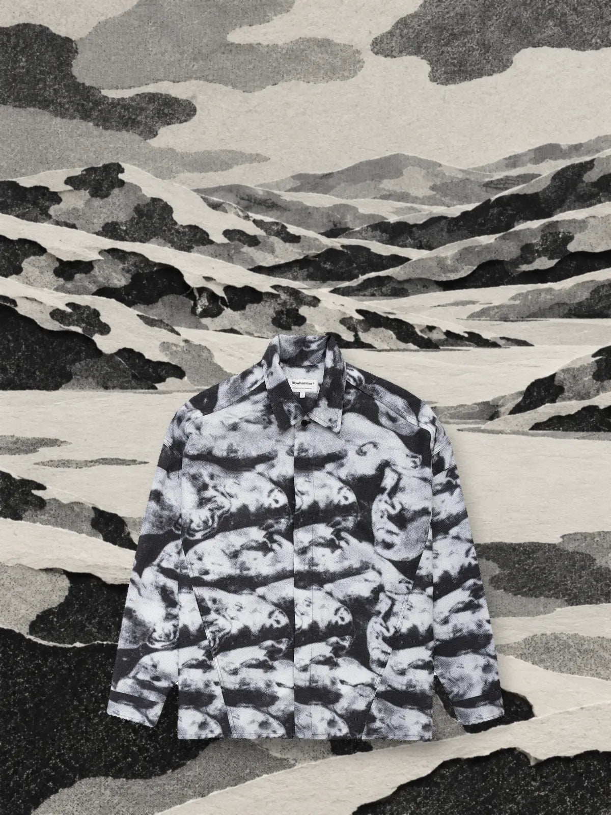 La camisa de manga larga Black Camo en un valle de colinas de papel cortadas con las mismas formas que el camuflaje.