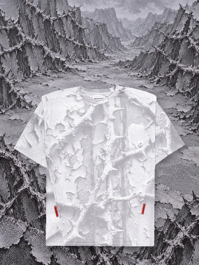 La t-shirt bianca Bloodrose White davanti a montagne di rovi di carta grigia in rilievo.