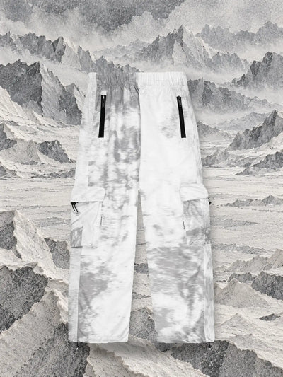The grey Grey Noise cargo trousers in front of ridges of grey and white tissue paper, like a glacier.