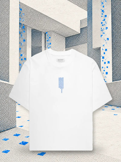 La t-shirt bianca Litkid in una stanza di carta bianca, dove cade una pioggia di quadratini di carta blu.