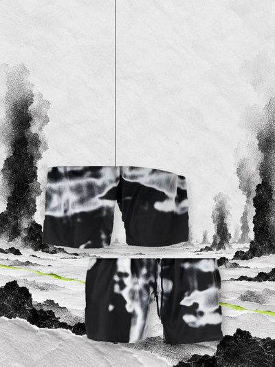 The black and white Rift Carbon swim shorts seen from the back, hanging on a thread, and from the front, on paper snow among columns of black smoke.