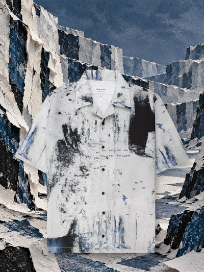 La camicia a maniche corte bianca Rugged fra pareti di carta strappata bianca e blu.