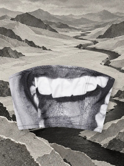 Il top grigio e bianco Smile in una valle di carta grigia, vicino a un fiume scuro.