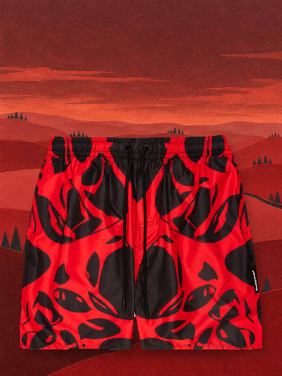 The red and black Strand Red swim shorts in a valley of red paper hills.