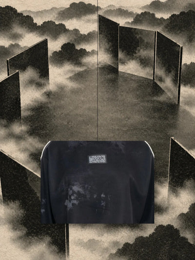 Et stykke af printet fra den korte sorte sweatshirt Triodrome, hængt i en tråd mellem paneler af mørkt papir og tåge.