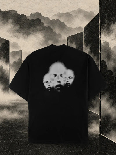 La t-shirt nera Triodrome fra pannelli di carta scura e nebbia color sabbia.