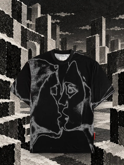 La t-shirt nera Unkiss Black fra cubi di carta strappata bianca e nera, sotto un cielo grigio.