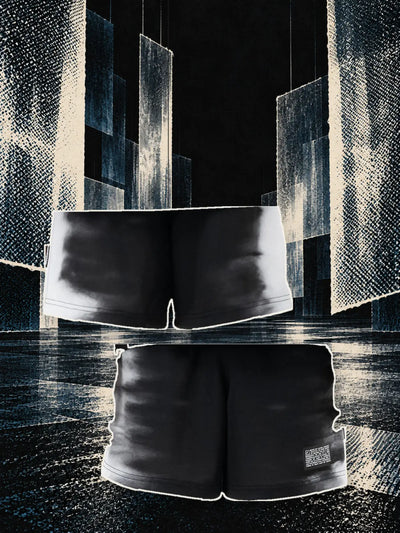 The black X-Ray bermuda shorts seen from the back, hanging on a thread, and from the front, in a hall of paper sheets hanging against the light.