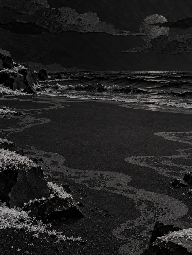 Una spiaggia di notte con onde e scogli resi come una foto, e una luna che nessuno aveva chiesto.